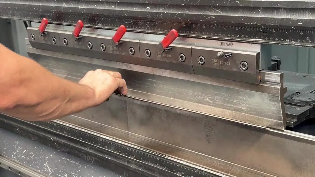 Manos posicionando una chapa en la plegadora de IMGAR