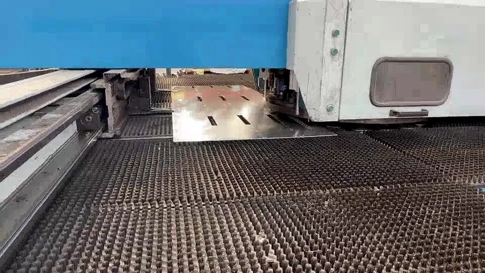 Chapa con ranuras sobre la mesa de cepillos de la punzonadora
