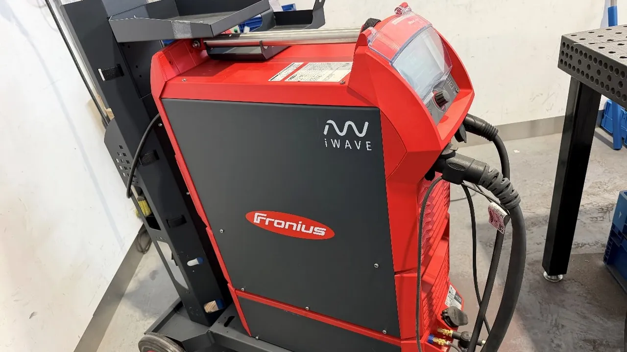Equipo de soldadura TIG Fronius iWave sobre su carro, junto a la mesa de soldadura de IMGAR
