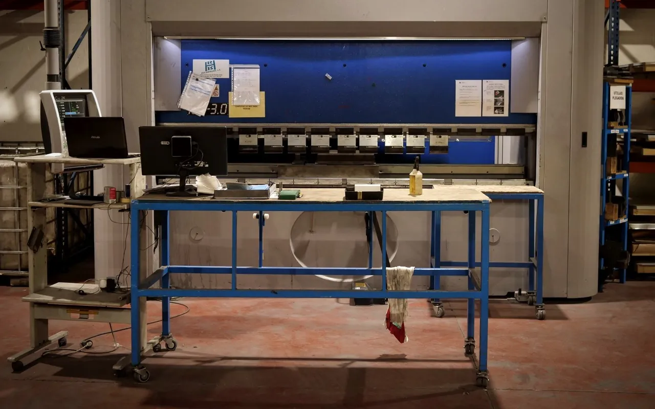 Puesto de trabajo con mesa de montaje frente a la plegadora CNC del taller de IMGAR