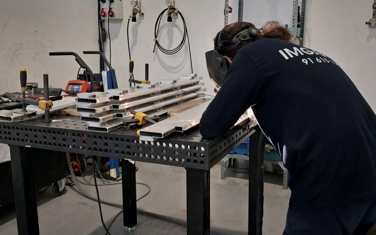 Soldador de IMGAR soldando perfiles de aluminio sobre la mesa de soldadura